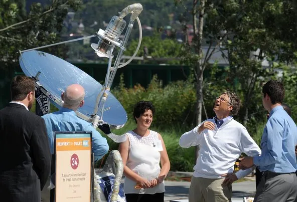 Bill Gates examining a working toilet prototype at the fair